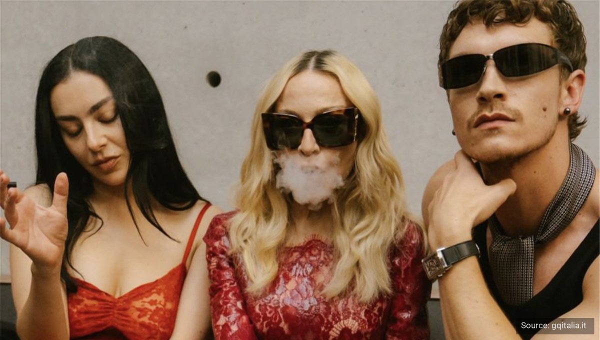 A woman in dark sunglasses and a red lace top exhaling smoke at a party.