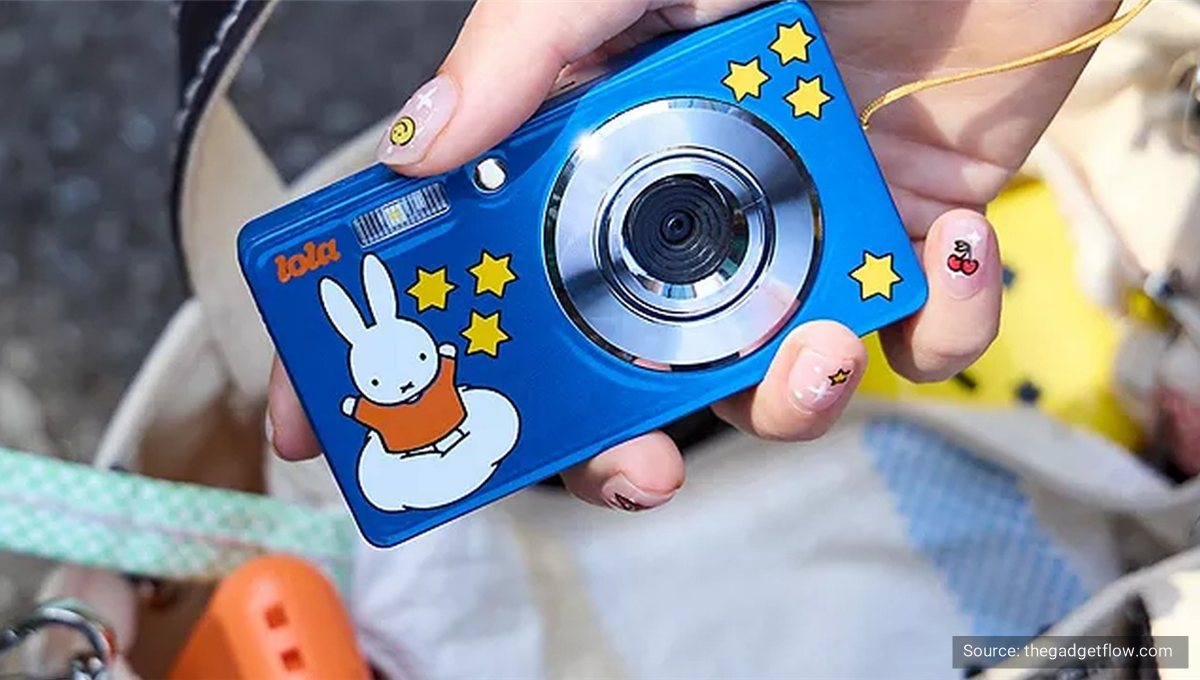 A small blue toy camera decorated with Miffy and yellow stars, held in one hand.