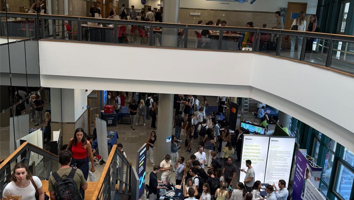 Students crossing the atrium and stairs of a university building.